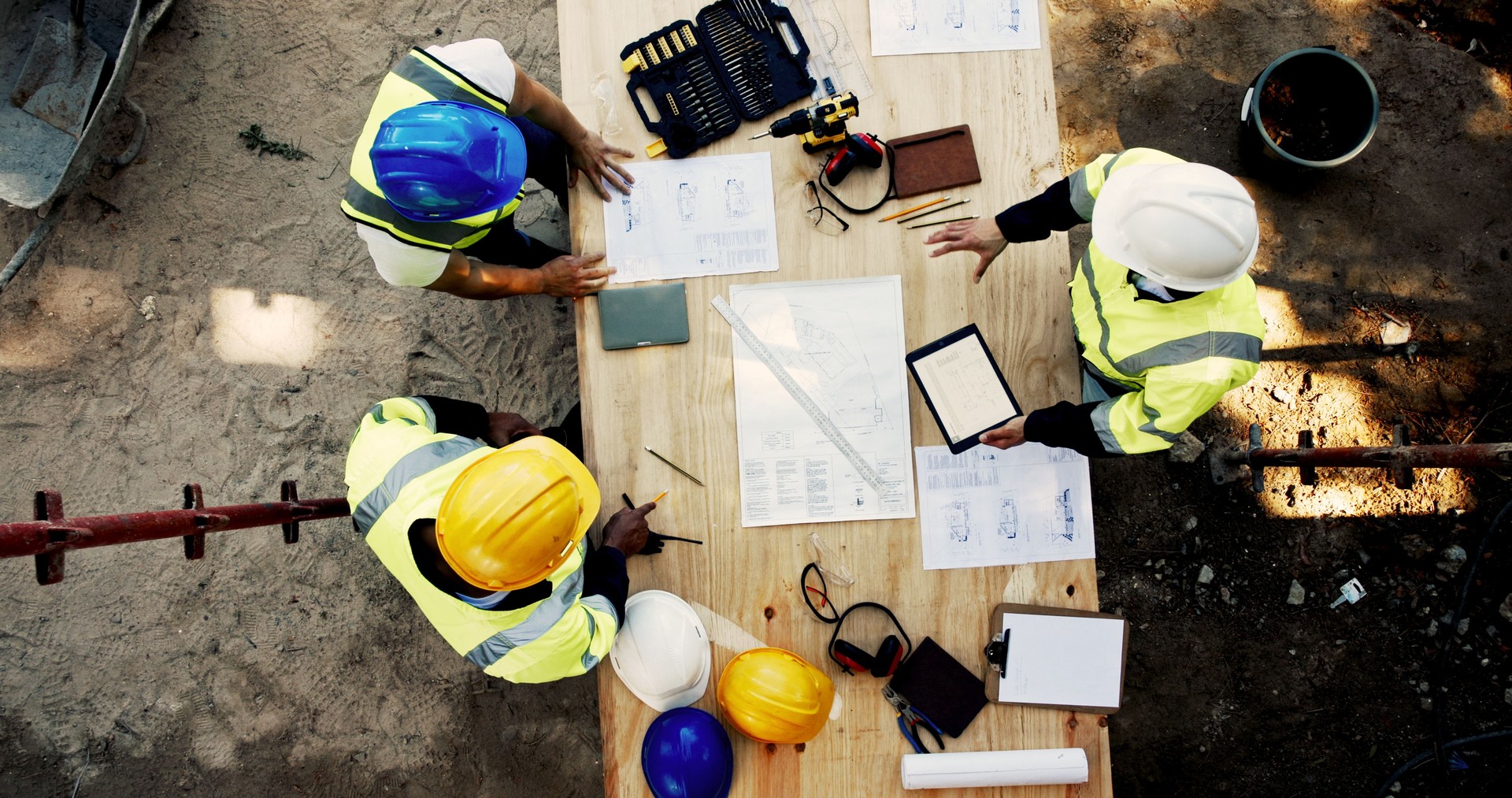 Construction site, business people and planning with tablet for architecture, building and blueprint. Above, engineer team and employees with ideas for industry renovation, infrastructure and meeting